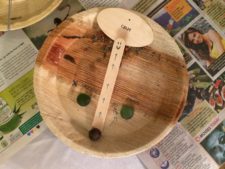 A wooden bowl with a paddle on top of it.