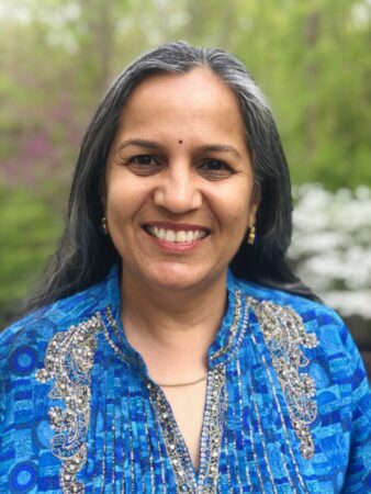 A woman in blue shirt smiling for the camera.